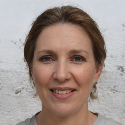 Joyful white adult female with medium  brown hair and grey eyes