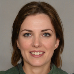 Joyful white young-adult female with medium  brown hair and green eyes