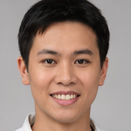 Joyful asian young-adult male with short  brown hair and brown eyes