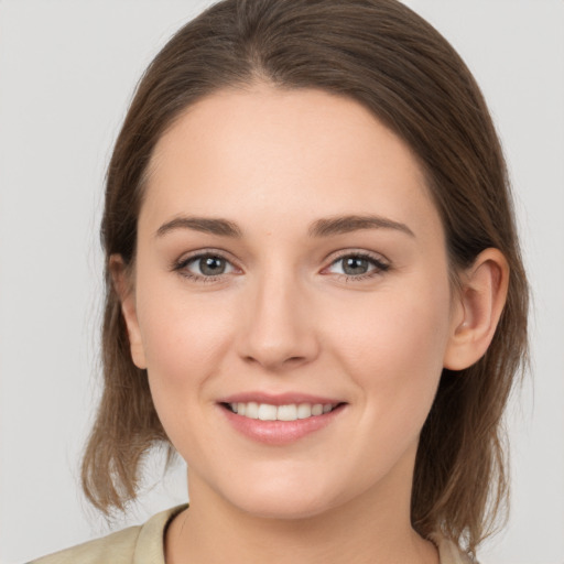 Joyful white young-adult female with medium  brown hair and grey eyes