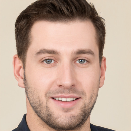 Joyful white young-adult male with short  brown hair and grey eyes