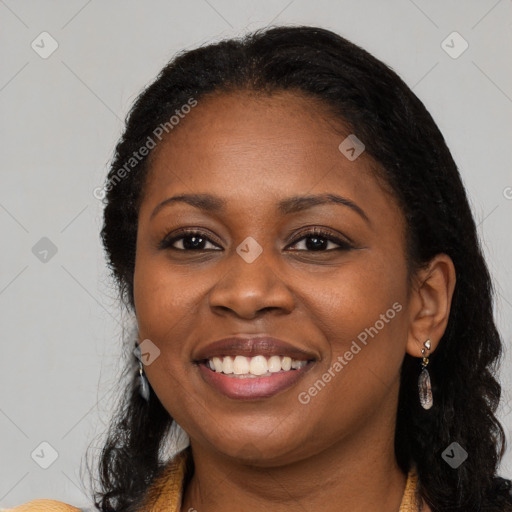 Joyful black young-adult female with long  black hair and brown eyes