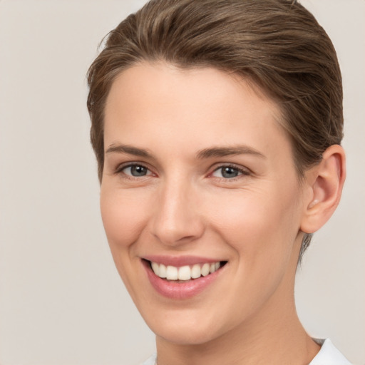 Joyful white young-adult female with short  brown hair and brown eyes