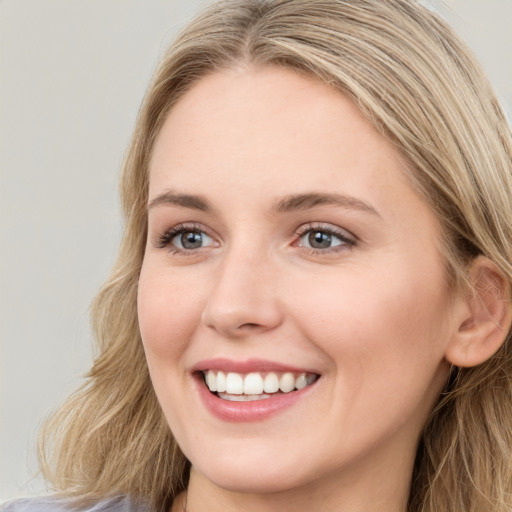 Joyful white young-adult female with long  brown hair and green eyes