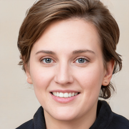 Joyful white young-adult female with medium  brown hair and blue eyes