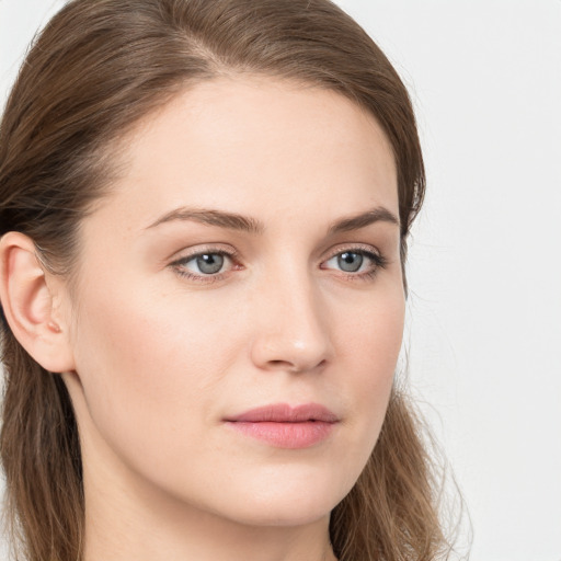 Joyful white young-adult female with long  brown hair and blue eyes