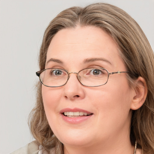 Joyful white adult female with long  brown hair and blue eyes