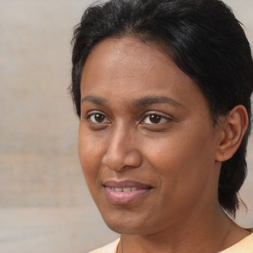 Joyful black adult female with medium  brown hair and brown eyes