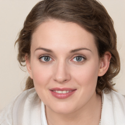 Joyful white young-adult female with medium  brown hair and green eyes