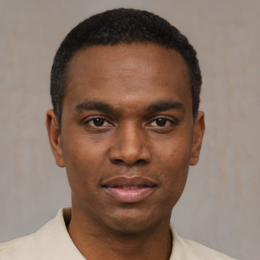 Joyful black young-adult male with short  black hair and brown eyes