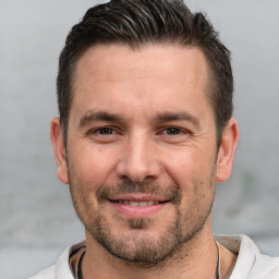 Joyful white adult male with short  brown hair and brown eyes