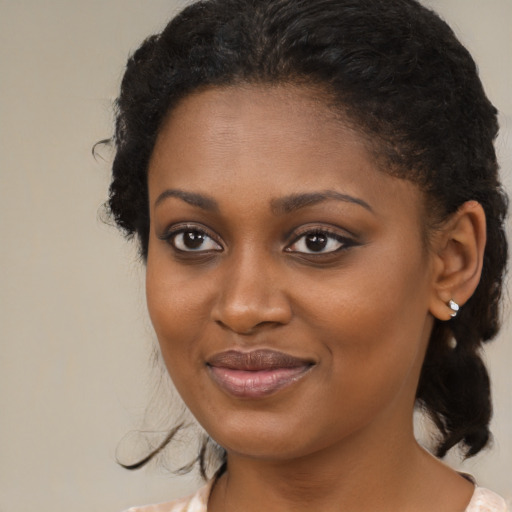 Joyful black young-adult female with medium  brown hair and brown eyes