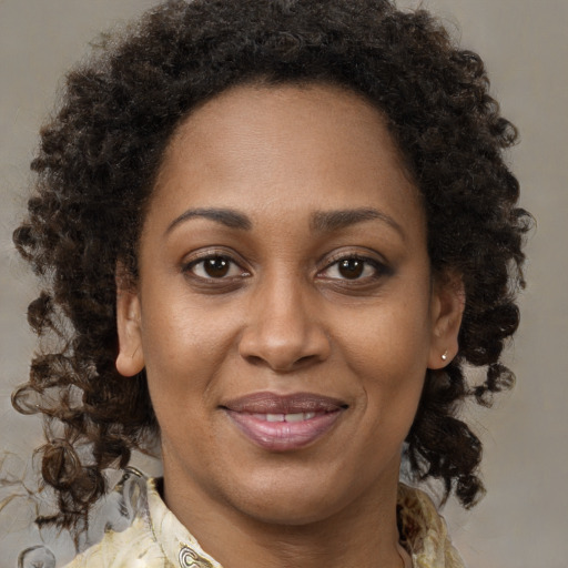 Joyful black adult female with medium  brown hair and brown eyes