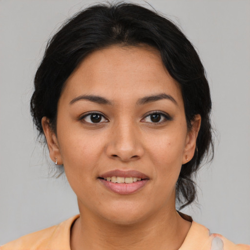 Joyful latino young-adult female with medium  brown hair and brown eyes