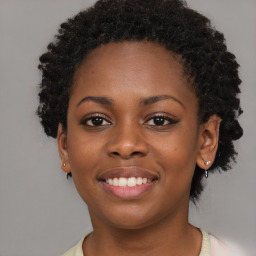 Joyful black young-adult female with short  black hair and brown eyes