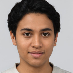 Joyful latino young-adult male with short  black hair and brown eyes