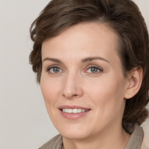 Joyful white adult female with medium  brown hair and grey eyes