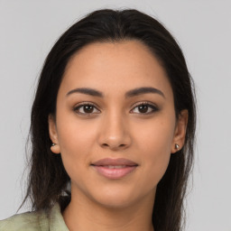 Joyful latino young-adult female with long  brown hair and brown eyes