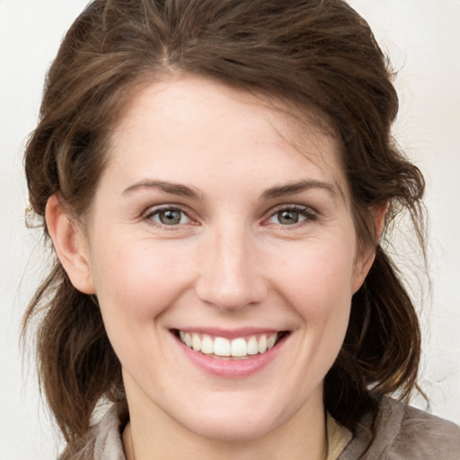 Joyful white young-adult female with medium  brown hair and grey eyes