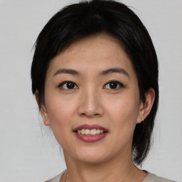 Joyful asian young-adult female with medium  black hair and brown eyes