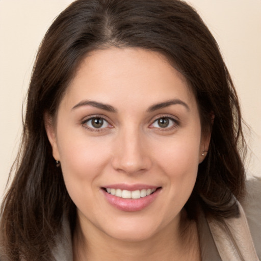 Joyful white young-adult female with long  brown hair and brown eyes