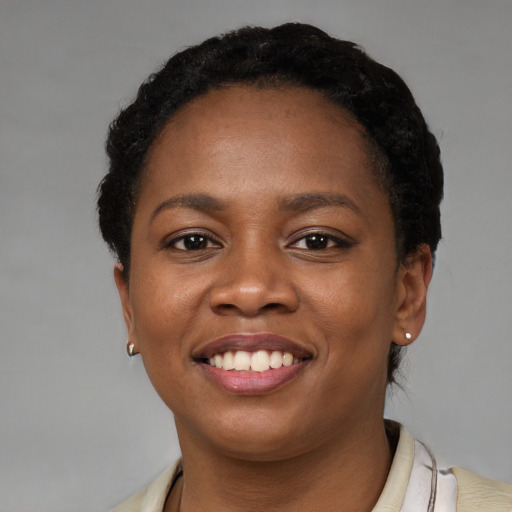 Joyful black young-adult female with short  black hair and brown eyes