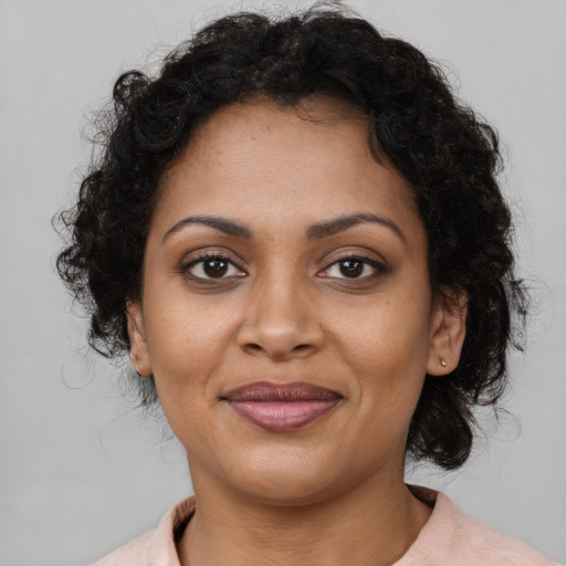 Joyful black young-adult female with medium  brown hair and brown eyes