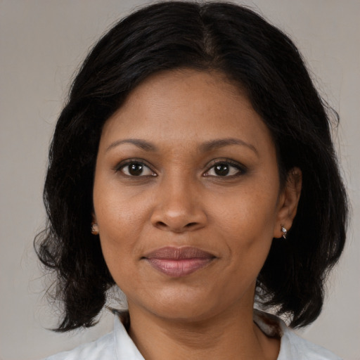 Joyful black adult female with medium  black hair and brown eyes