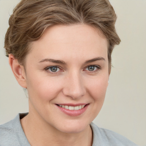 Joyful white young-adult female with short  brown hair and grey eyes