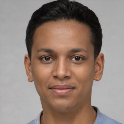 Joyful latino young-adult male with short  black hair and brown eyes