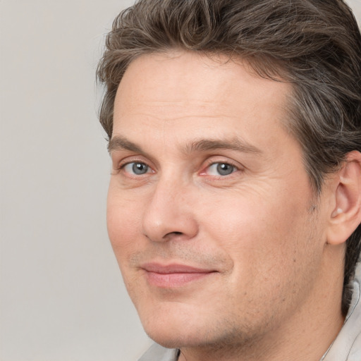 Joyful white adult male with short  brown hair and grey eyes