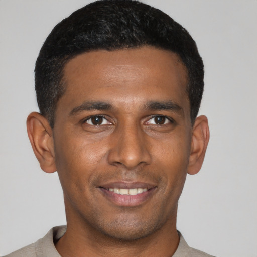 Joyful latino young-adult male with short  black hair and brown eyes