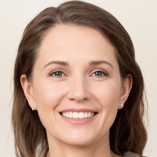 Joyful white young-adult female with medium  brown hair and grey eyes