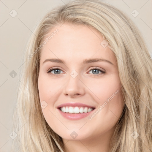 Joyful white young-adult female with long  brown hair and blue eyes