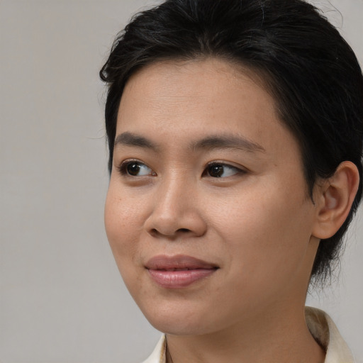 Joyful asian young-adult female with medium  brown hair and brown eyes