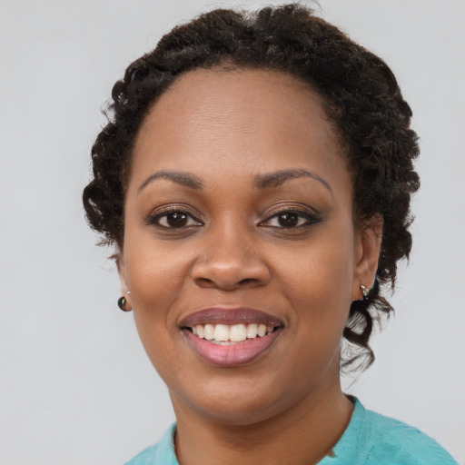 Joyful black young-adult female with short  brown hair and brown eyes