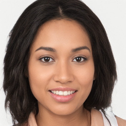 Joyful latino young-adult female with long  brown hair and brown eyes