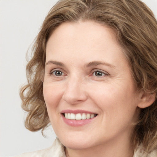 Joyful white young-adult female with medium  brown hair and green eyes