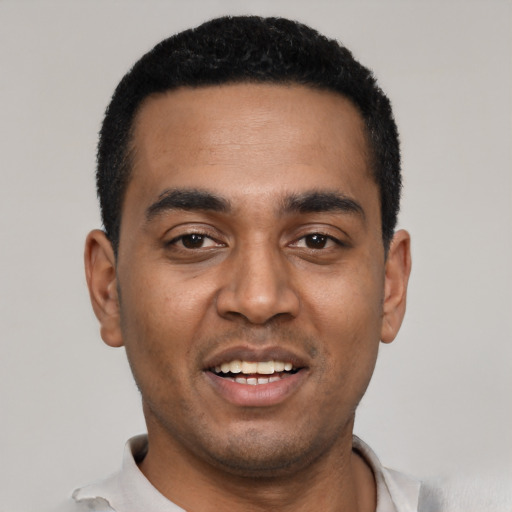 Joyful black young-adult male with short  black hair and brown eyes