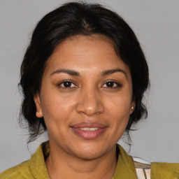 Joyful black adult female with medium  brown hair and brown eyes