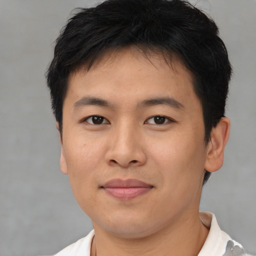 Joyful asian young-adult male with short  brown hair and brown eyes