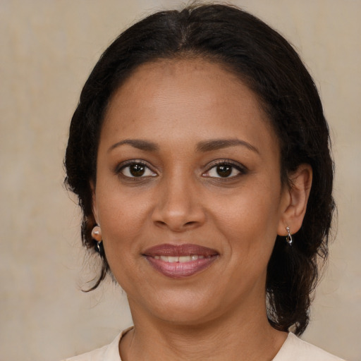Joyful black young-adult female with medium  brown hair and brown eyes