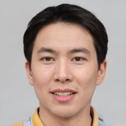 Joyful asian young-adult male with short  brown hair and brown eyes