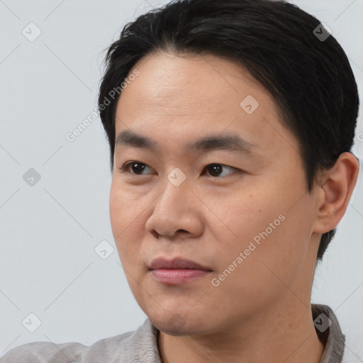 Joyful asian young-adult male with short  black hair and brown eyes