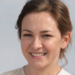 Joyful white adult female with medium  brown hair and brown eyes