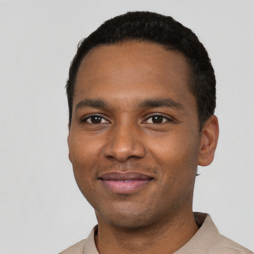 Joyful black young-adult male with short  black hair and brown eyes