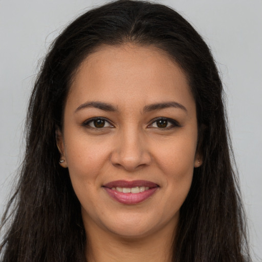 Joyful latino young-adult female with long  brown hair and brown eyes
