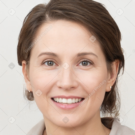 Joyful white young-adult female with medium  brown hair and grey eyes