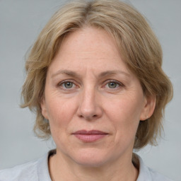 Joyful white adult female with medium  brown hair and blue eyes