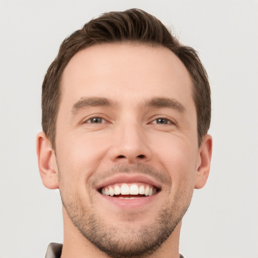 Joyful white young-adult male with short  brown hair and brown eyes